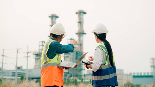 two engineers using a digital tablet together in an industrial place of work.